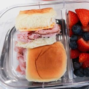 two ham sliders in a glass lunch container