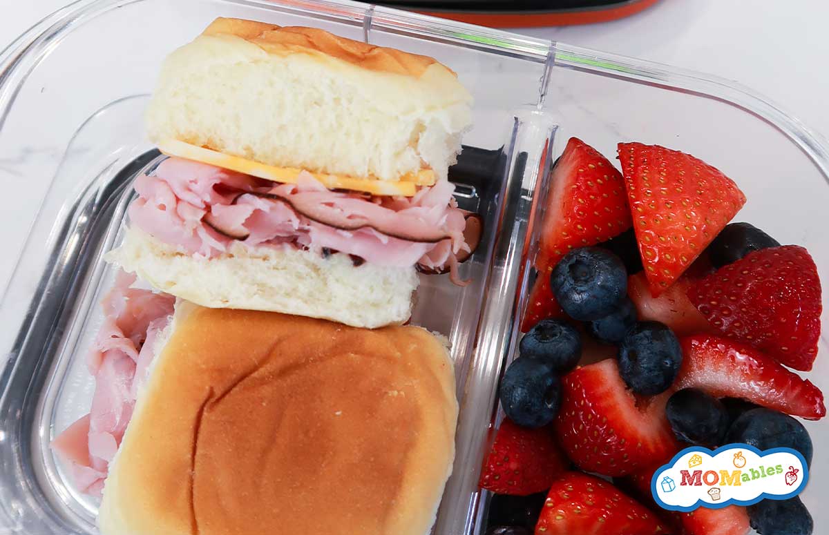 ham sliders in a lunchbox with fresh berries