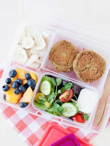 small salad, with two falafels, and fruit in a lunch container