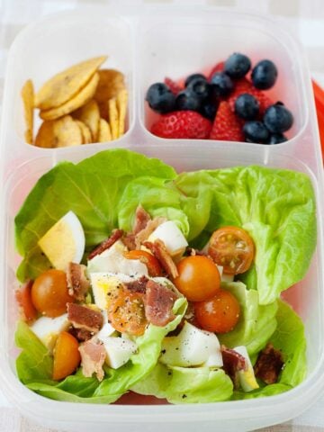 hard boiled egg salad in a lunch container with fruit