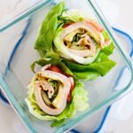 two turkey avocado lettuce wraps in a glass lunch container