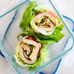 two turkey avocado lettuce wraps in a glass lunch container