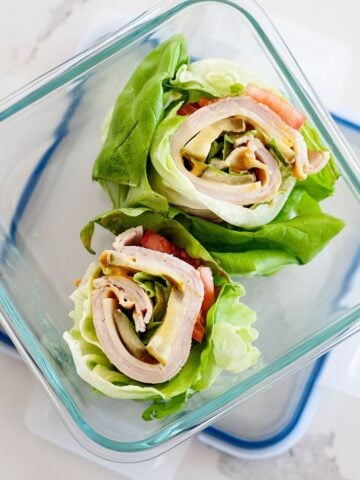 two turkey avocado lettuce wraps in a glass lunch container