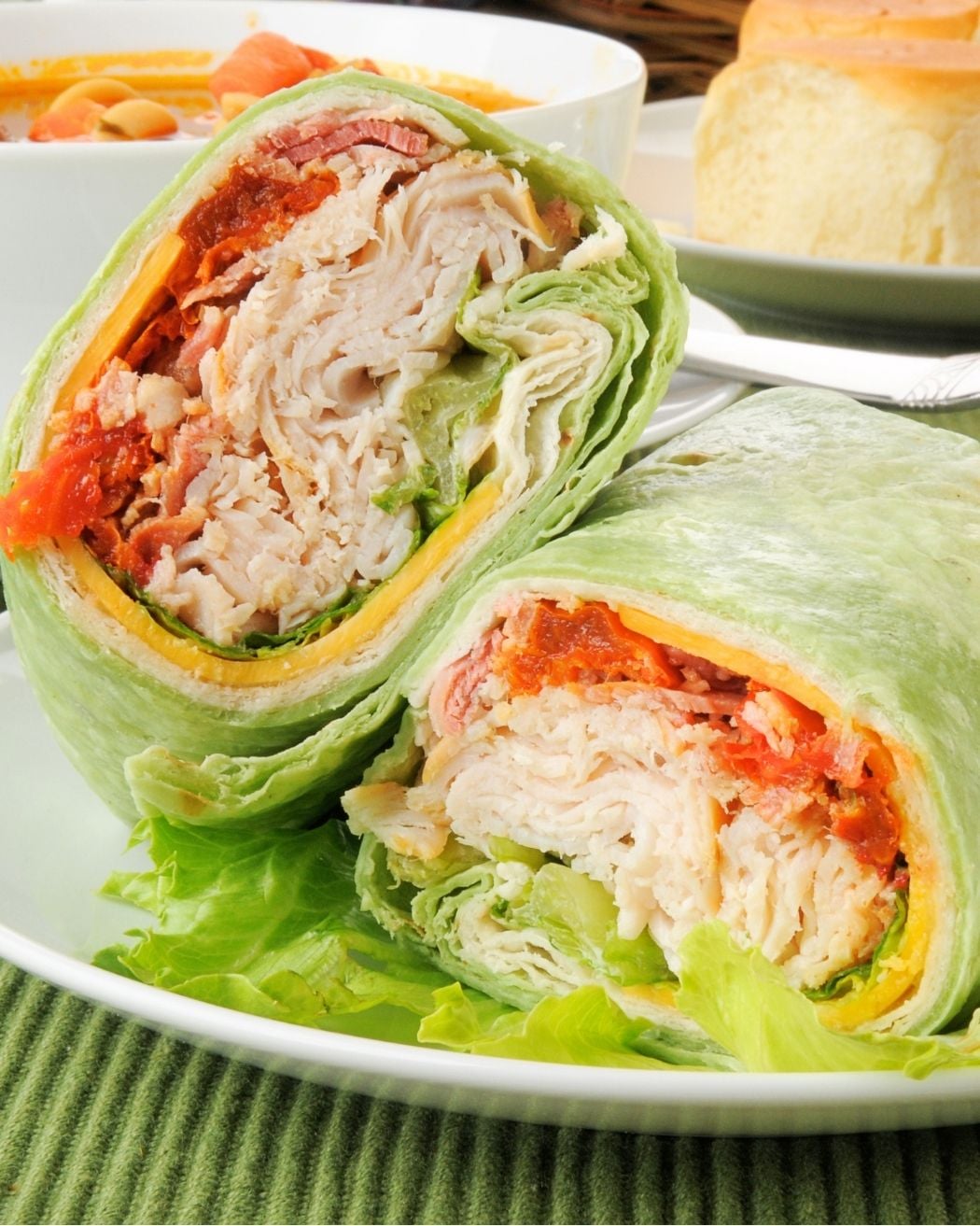 a turkey bacon wrap cut in half on a plate