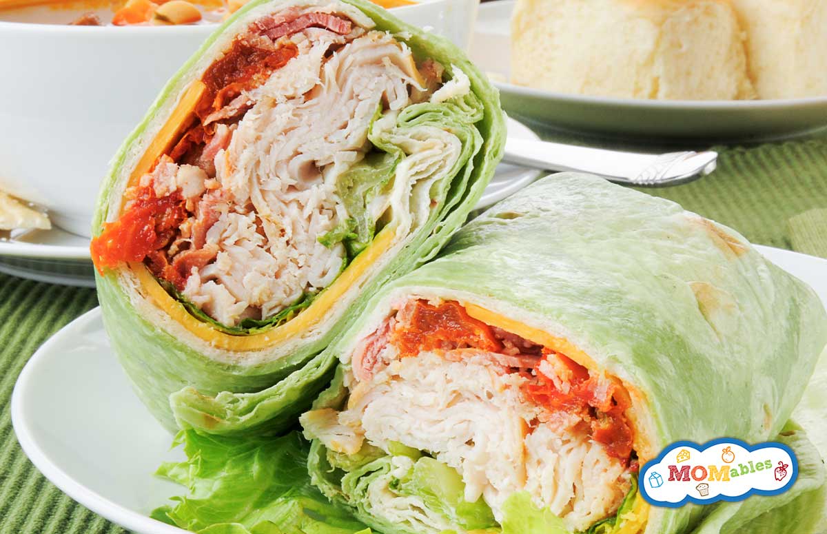 a turkey bacon wrap cut in half on a plate