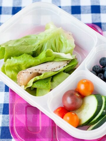 lettuce turkey wrap with vegetables in a school lunch container
