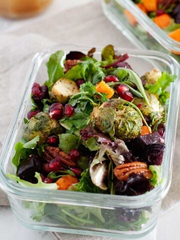 a large winter salad in a glass lunch container