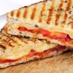 ham tomato an cheese panini cut in half
