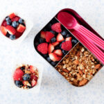 yogurt parfait in a small lunch container with mixed berries and granola