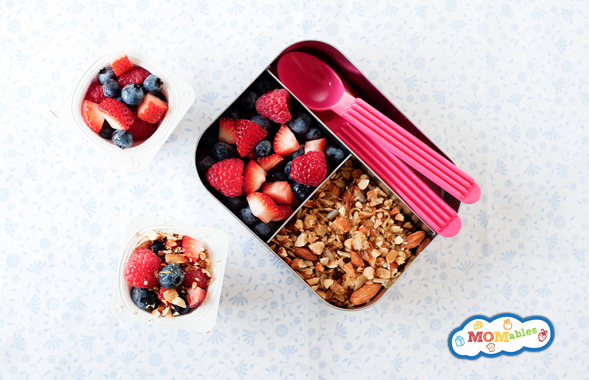 yogurt parfait in a small lunch container with mixed berries and granola