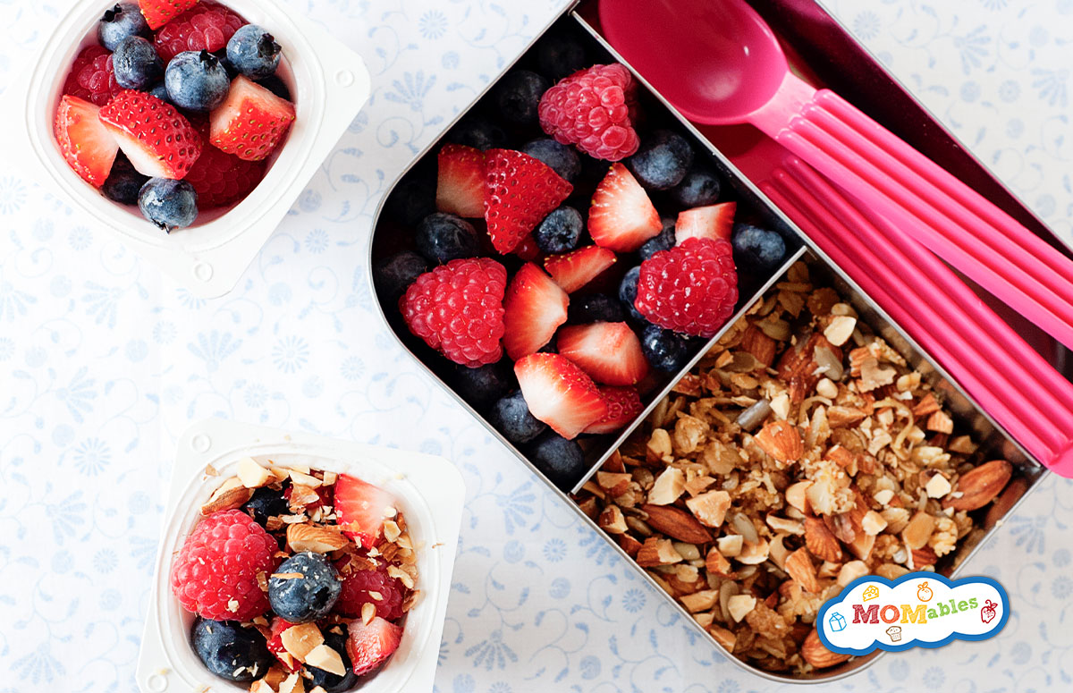 yogurt parfait in a small lunch container with mixed berries and granola