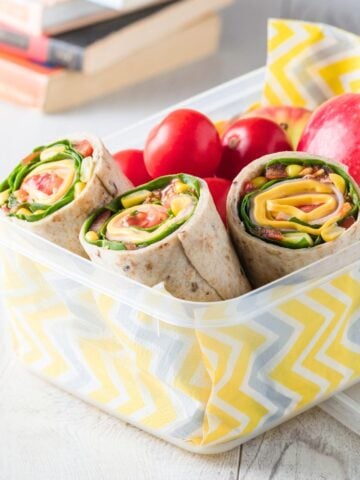 closeup of ham and veggie wraps in a lunchbox