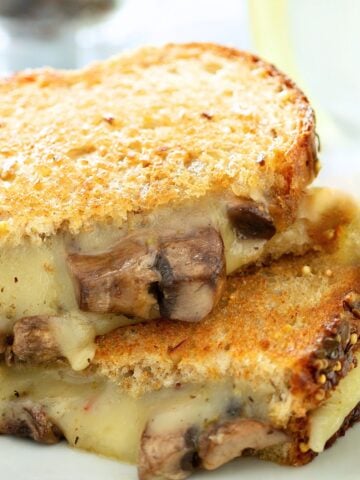 a mushroom grilled cheese sandwich sliced in half and stacked.