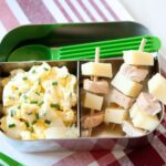 egg salad with skewers of ham and cheese in a lunch container