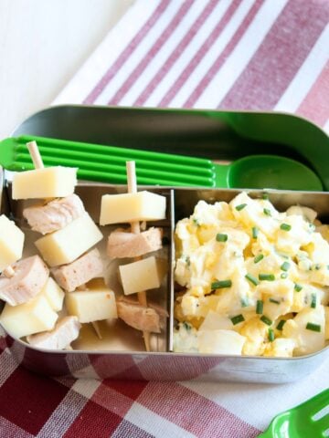 egg salad with skewers of ham and cheese in a lunch container
