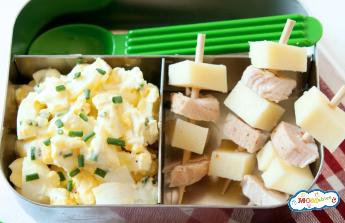 egg salad with skewers of ham and cheese in a lunch container