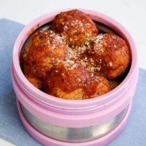 a thermos filled with hot meatballs in tomato sauce ready to be packed for school in a lunchbox