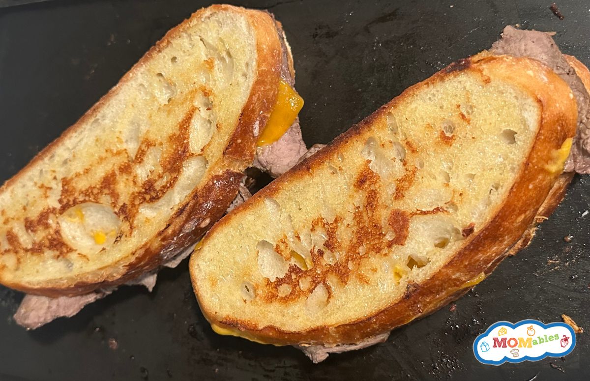 two roast beef grilled cheese sandwiches on a pan