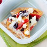 two pita and hummus pizza slices in a lunch container