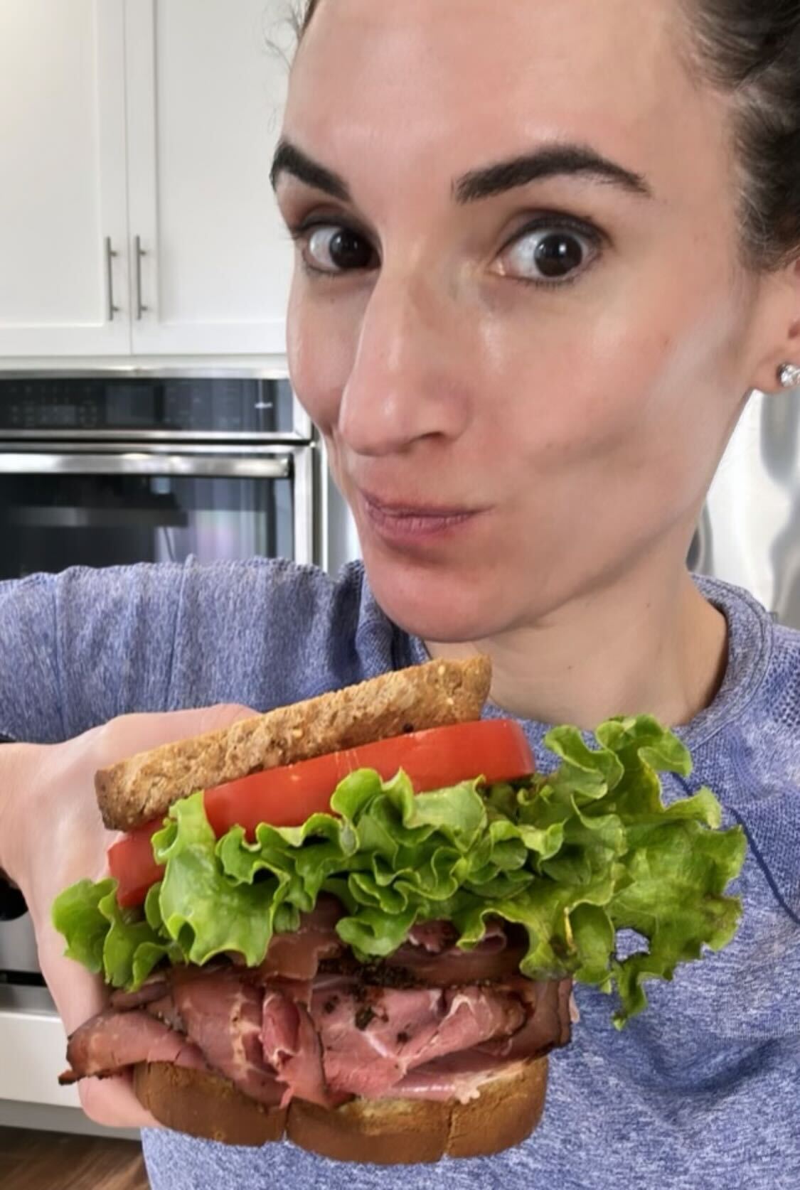 Laura fuentes holding a large sandwich