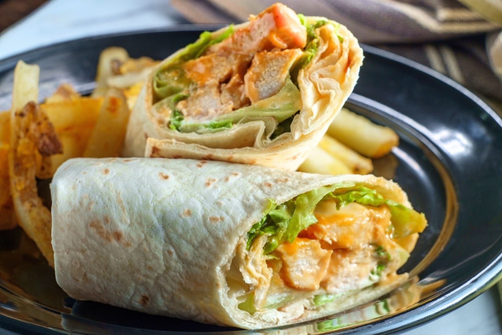 buffalo chicken wrap cut in half on a plate