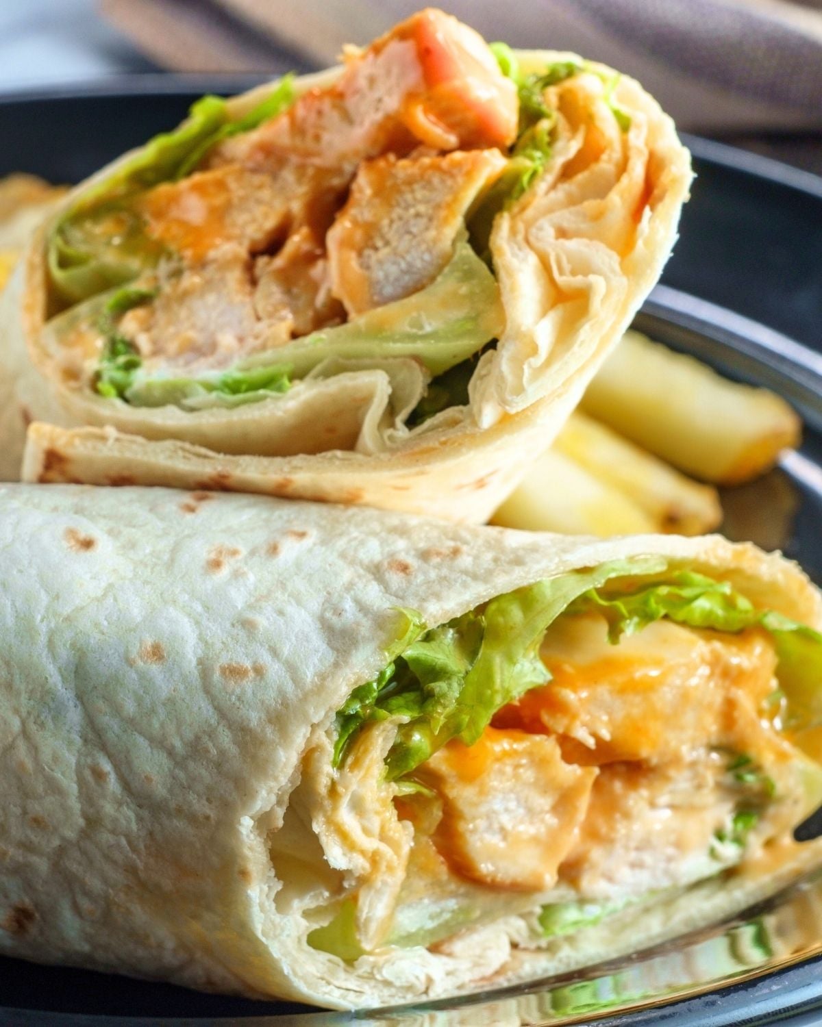 buffalo chicken wrap cut in half on a plate