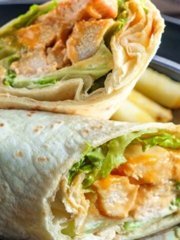 buffalo chicken wrap cut in half on a plate