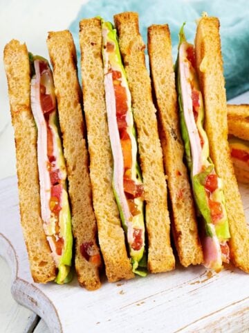 three club sandwiches on a cutting board