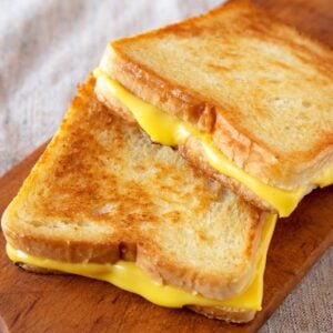 two grilled cheese sandwiches on a small cutting board