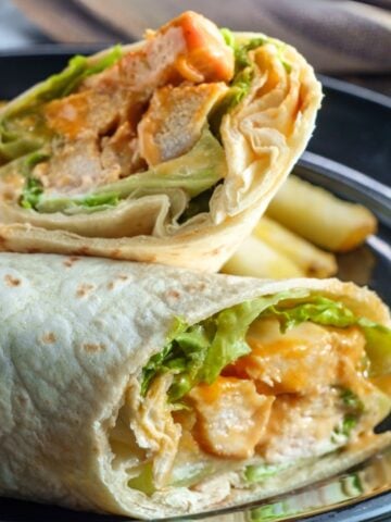 two halves of a buffalo chicken wrap on a plate