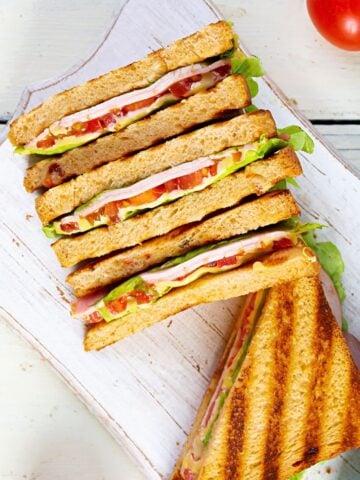 four club sandwiches on a cutting board