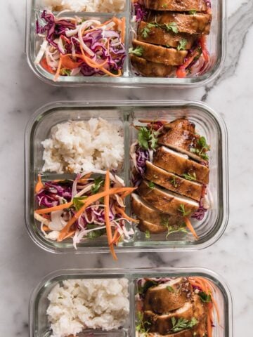 top view of three lunchboxes with korean chicken, rice, and veggies