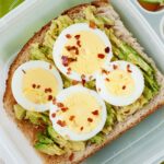 top view of an avocado toast topped with hard boiled egg in a lunchbox