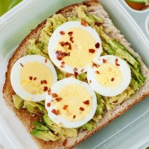 top view of an avocado toast topped with hard boiled egg in a lunchbox