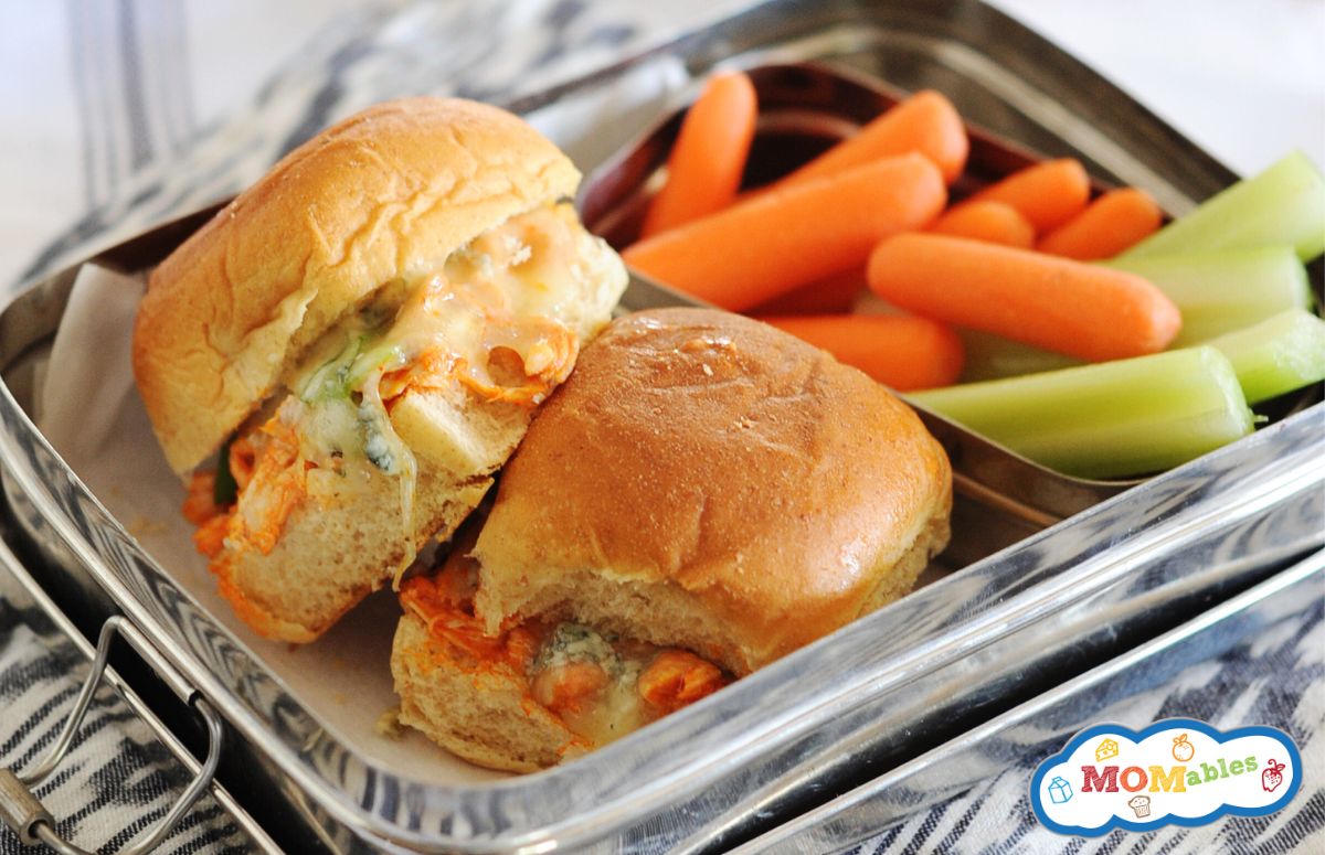 lunchbox with 2 buffalo chicken sliders and some veggies on the side